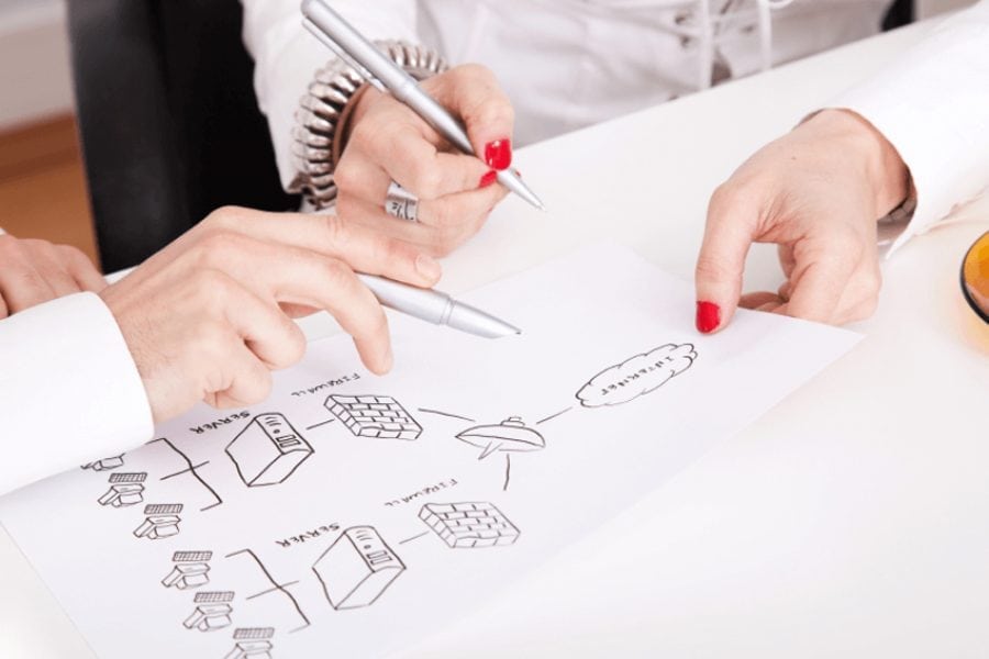 Two people discussing a paper holding pens