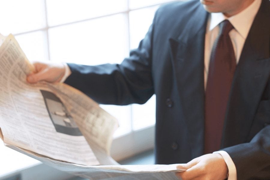 Man in suit reading a news paper